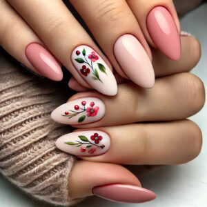 "Almond-shaped nails with a soft pink base, adorned with small, delicately painted red flowers and green leaves. The floral accents are minimalistic and strategically placed, enhancing the elegance of the nails with a refined, feminine touch."