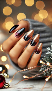 A close-up of almond-shaped nails with a glamorous ombre design. The nails start with a deep burgundy or black base color and blend seamlessly into shimmering gold or silver glitter at the tips. The elegant gradient adds a festive, sophisticated touch. The background is softly blurred, featuring subtle holiday-themed elements like glowing string lights, enhancing the luxurious and festive atmosphere of the nail design.