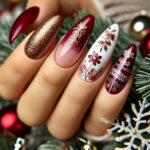 A close-up of chic, almond-shaped nails with a Christmas theme. The nails feature festive designs, including a glossy deep red with golden glitter accents and a white base with delicate snowflake patterns and silver glitter. The background is softly blurred, showcasing Christmas decorations such as pine branches, glowing string lights, and ornaments in gold, red, and green, enhancing the holiday atmosphere.